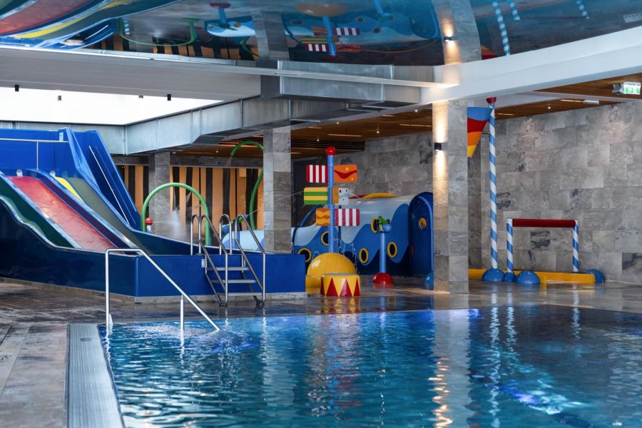 Area of the indoor children's pool with water slides, toys, and a large swimming pool. Area of the indoor children's pool with water slides, toys, and a large swimming pool.